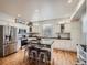 Modern kitchen with stainless appliances, center island with seating and black countertops at 8367 Devinney St, Arvada, CO 80005