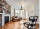 Cozy living room featuring hardwood floors, a fireplace with a rustic wood accent wall, and ample natural light at 8367 Devinney St, Arvada, CO 80005