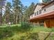 Exterior side view of the barn with green metal railing and an open grassy pasture at 23076 Oehlmann Park Rd, Conifer, CO 80433