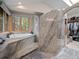 Relaxing bathroom with soaking tub, walk-in shower, and walk-in closet at 23076 Oehlmann Park Rd, Conifer, CO 80433
