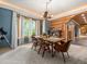 Bright dining room with unique chandelier, light blue walls and backyard views through large, bright windows at 23076 Oehlmann Park Rd, Conifer, CO 80433