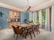 Elegant dining room features custom chandelier, built-in cabinet, and large windows providing outdoor views at 23076 Oehlmann Park Rd, Conifer, CO 80433