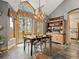 Bright dining area with stylish chandelier, wood table, hutch and backyard view from large picture window at 23076 Oehlmann Park Rd, Conifer, CO 80433