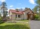 Charming home with a red roof, wooden porch, and lovely front yard at 23076 Oehlmann Park Rd, Conifer, CO 80433