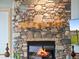 A cozy stone fireplace with a wooden mantle and decorative elements adds warmth and character at 23076 Oehlmann Park Rd, Conifer, CO 80433