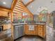 Gourmet kitchen with granite countertops, stainless steel dishwasher, wood cabinets, and scenic backyard views at 23076 Oehlmann Park Rd, Conifer, CO 80433