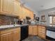 Kitchen with wooden cabinetry, dark countertops, black appliances, and tile backsplash at 23076 Oehlmann Park Rd, Conifer, CO 80433