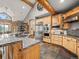Chef's kitchen featuring stainless steel appliances, granite countertops, tile flooring and wood cabinets at 23076 Oehlmann Park Rd, Conifer, CO 80433