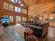 Open-concept living area with log walls, vaulted ceilings, stone floors, and abundant natural light at 23076 Oehlmann Park Rd, Conifer, CO 80433