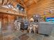 Expansive log home interior featuring a stone fireplace, soaring ceilings, and unique wood accents at 23076 Oehlmann Park Rd, Conifer, CO 80433