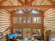 Spacious log cabin living room with vaulted ceilings and large windows providing natural light and scenic views at 23076 Oehlmann Park Rd, Conifer, CO 80433