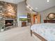 Stone fireplace as focal point in a main bedroom with vaulted ceiling and hardwood trim at 23076 Oehlmann Park Rd, Conifer, CO 80433