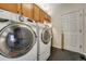 Functional laundry room features a washer, dryer, and storage cabinets, all on a stylish tile floor at 17798 E Ida Ave, Centennial, CO 80015