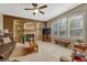 Inviting living room features a fireplace, built-in shelving, a ceiling fan, and a large window with plantation shutters at 17798 E Ida Ave, Centennial, CO 80015