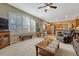 Comfortable living room flows into the kitchen, featuring a large window with shutters and a ceiling fan at 17798 E Ida Ave, Centennial, CO 80015