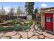 Landscaped backyard featuring a pond with a waterfall, stone pathways, and a charming red door at 3242 Utica St, Denver, CO 80212