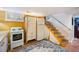 Basement kitchenette with full sized fridge, stove and terra cotta tile flooring at 3242 Utica St, Denver, CO 80212