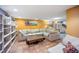 Basement living area with tile floors, large sofa, and bright colored walls at 3242 Utica St, Denver, CO 80212