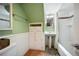 Traditional bathroom with pedestal sink, tub and shower combo, storage cabinet, and tiled floor at 3242 Utica St, Denver, CO 80212