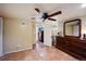 Bedroom with terracotta tile flooring, ceiling fan, and dresser; laundry room visible through open door at 3242 Utica St, Denver, CO 80212