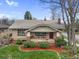 Charming brick home with a cozy front porch, manicured lawn, and mature trees at 3242 Utica St, Denver, CO 80212