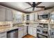 Bright kitchen features white cabinets, granite countertops, stainless steel appliances, and a ceiling fan at 3242 Utica St, Denver, CO 80212