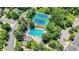 Aerial view of a community pool and tennis courts surrounded by lush trees and green spaces in a neighborhood at 2980 W Long Dr # E, Littleton, CO 80120