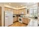 Bright kitchen featuring white appliances, light cabinets, and granite countertops at 2980 W Long Dr # E, Littleton, CO 80120