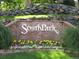 Neighborhood entrance sign with rock facade, flowers, and manicured lawn at 2980 W Long Dr # E, Littleton, CO 80120