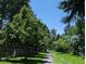 A walking path surrounded by mature trees and lush greenery on either side create a park-like feel at 2980 W Long Dr # E, Littleton, CO 80120