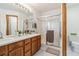 Bathroom featuring double sink vanity, framed mirror, glass-enclosed shower, and tiled floors at 13755 W Amherst Way, Lakewood, CO 80228