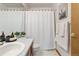 Bright bathroom featuring a single vanity, toilet, framed mirror, and shower with white shower curtain at 13755 W Amherst Way, Lakewood, CO 80228