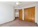 Bedroom featuring neutral carpet, closet with sliding doors, and hallway access at 13755 W Amherst Way, Lakewood, CO 80228