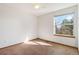 Bright bedroom featuring neutral carpet, white walls, and a window offering natural light and views of the outdoors at 13755 W Amherst Way, Lakewood, CO 80228