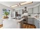 Well-lit kitchen with stainless steel appliances, a peninsula counter, and shaker style cabinets at 13755 W Amherst Way, Lakewood, CO 80228