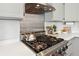 The updated kitchen features a stainless steel range hood and stove top at 13755 W Amherst Way, Lakewood, CO 80228