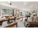 Bright living room boasts large windows, a dining area, and flows into the modern kitchen at 13755 W Amherst Way, Lakewood, CO 80228