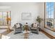 Living room with comfortable seating, a neutral rug, and bright natural light from a large window at 13755 W Amherst Way, Lakewood, CO 80228