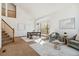 Open-concept living room and dining area with staircase, large windows, and natural light at 13755 W Amherst Way, Lakewood, CO 80228