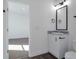 Clean bathroom with white vanity, granite countertop, modern mirror, and view of the bedroom at 60600 E 56Th Ave, Strasburg, CO 80136
