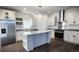 Modern kitchen features white cabinets, stainless steel appliances, granite countertops, and large center island at 60600 E 56Th Ave, Strasburg, CO 80136