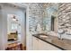 Bathroom sink with wall tile accent, a vanity and open doorway to the bedroom at 2060 Ash St, Denver, CO 80207