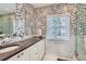 Modern bathroom with dual sinks, patterned accent wall and marble tile floor at 2060 Ash St, Denver, CO 80207