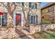 Close-up of the brick home's red front door, front porch and chairs at 2060 Ash St, Denver, CO 80207