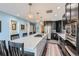 Open kitchen with island, cooktop, stainless appliances, and dark cabinetry at 2060 Ash St, Denver, CO 80207