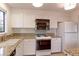 Well-lit kitchen with granite countertops, white cabinets, and modern stainless appliances at 4877 Darwin Ct, Boulder, CO 80301