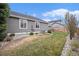 A manicured backyard with healthy lawn, gray siding, and lush landscaping at 9705 Westbury Cir, Highlands Ranch, CO 80129