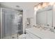 Bathroom featuring a stone tiled shower with glass doors, modern vanity and decorative mirror at 9705 Westbury Cir, Highlands Ranch, CO 80129