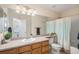Bright bathroom with a large mirror, and a tub with shower at 9705 Westbury Cir, Highlands Ranch, CO 80129
