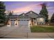 Charming home featuring a three car garage, well-manicured lawn, and attractive brick and siding details at 9705 Westbury Cir, Highlands Ranch, CO 80129
